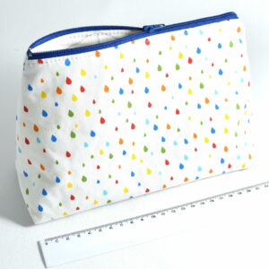 a white zip bag with a blue zipper and a colourful droplet pattern