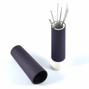 a black cylindrical holder with sewing needles in it.